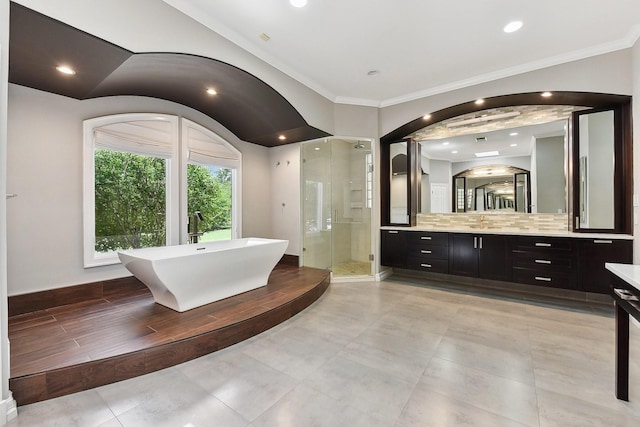 bathroom with independent shower and bath, ornamental molding, backsplash, and vanity