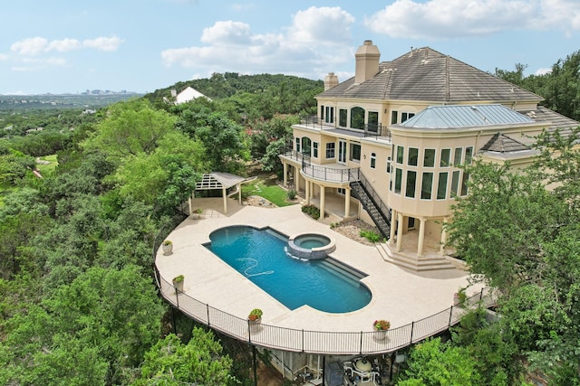 view of swimming pool featuring a patio and an in ground hot tub