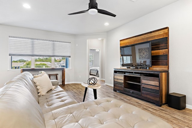 living room featuring light wood-type flooring and ceiling fan