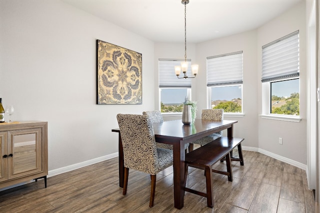 dining space with a healthy amount of sunlight, dark hardwood / wood-style floors, and a notable chandelier