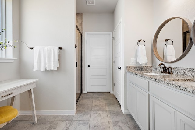 bathroom with a shower with door and vanity