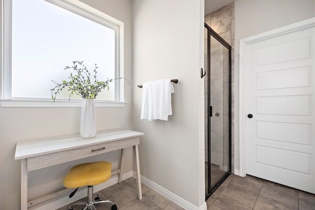 bathroom with a wealth of natural light and a shower with shower door