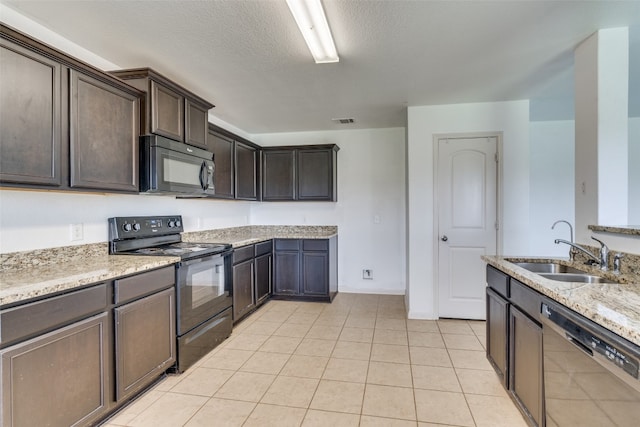 kitchen with black appliances, sink, light tile patterned floors, dark brown cabinetry, and light stone countertops