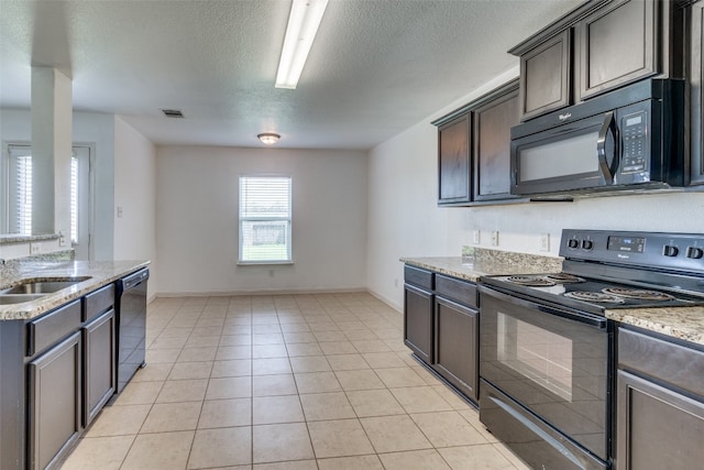 kitchen featuring dark brown cabinets, black appliances, light tile patterned floors, and light stone counters