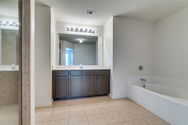 bathroom featuring separate shower and tub, tile patterned floors, vanity, and a textured ceiling