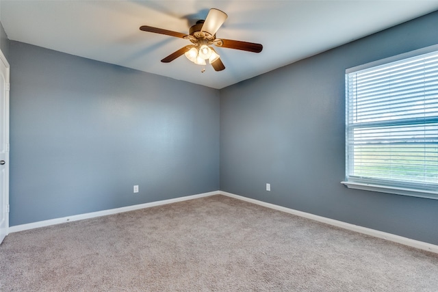 carpeted spare room with ceiling fan