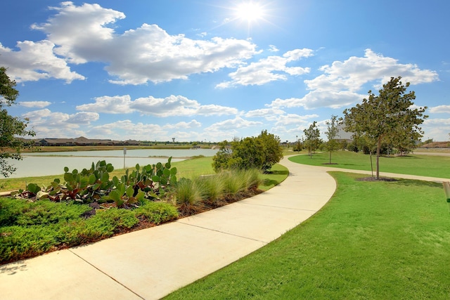 view of community with a lawn and a water view