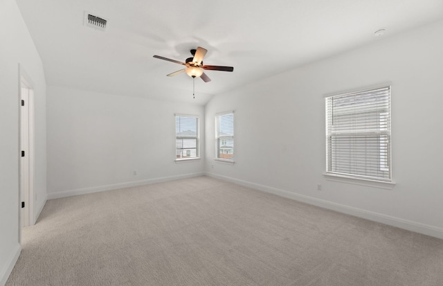 carpeted spare room featuring vaulted ceiling and ceiling fan