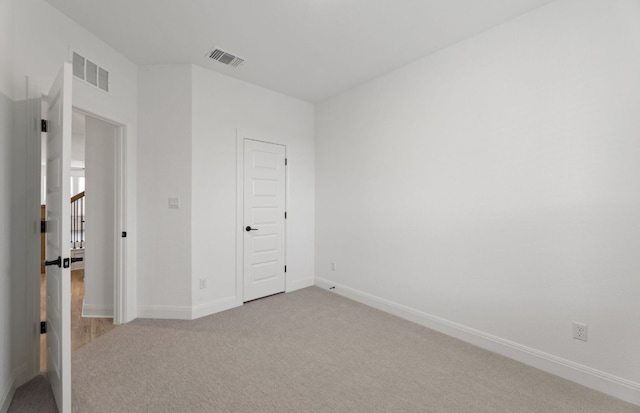 unfurnished bedroom with light carpet and a closet