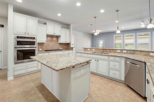 kitchen featuring pendant lighting, white cabinetry, stainless steel appliances, and sink