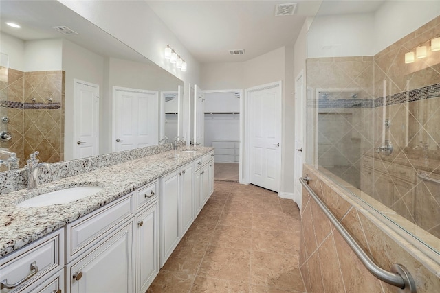 bathroom with vanity and a tile shower