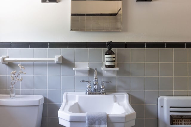 bathroom with toilet, sink, tile walls, and backsplash