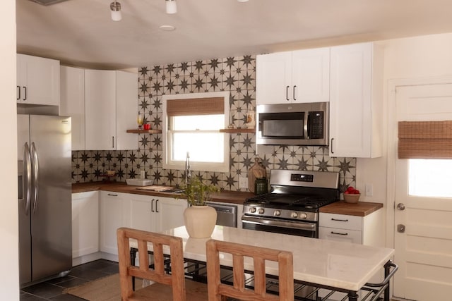 kitchen featuring white cabinetry, appliances with stainless steel finishes, and decorative backsplash