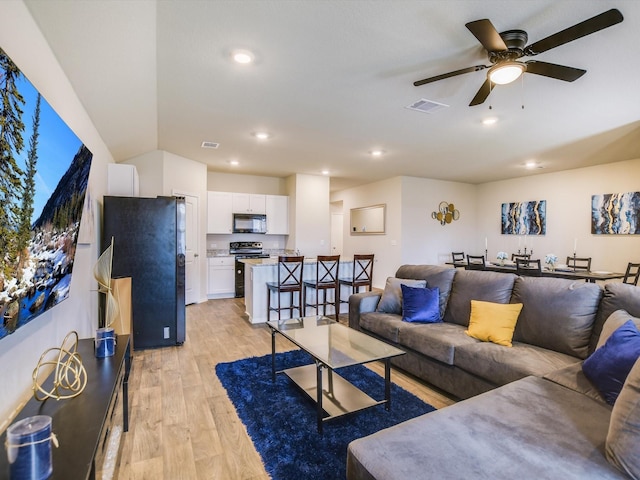 living room featuring light wood-type flooring and ceiling fan