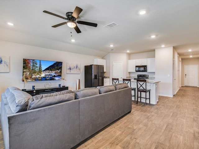 living room featuring ceiling fan and light hardwood / wood-style floors