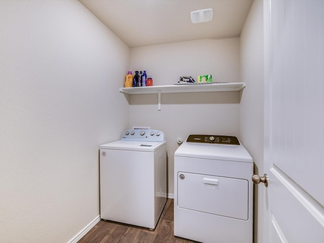 laundry room with washer and clothes dryer and dark wood-type flooring