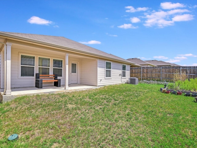 rear view of house featuring a patio, central AC, and a yard