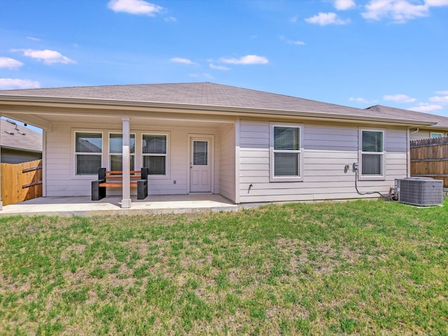 rear view of property with a patio area, central AC unit, and a lawn