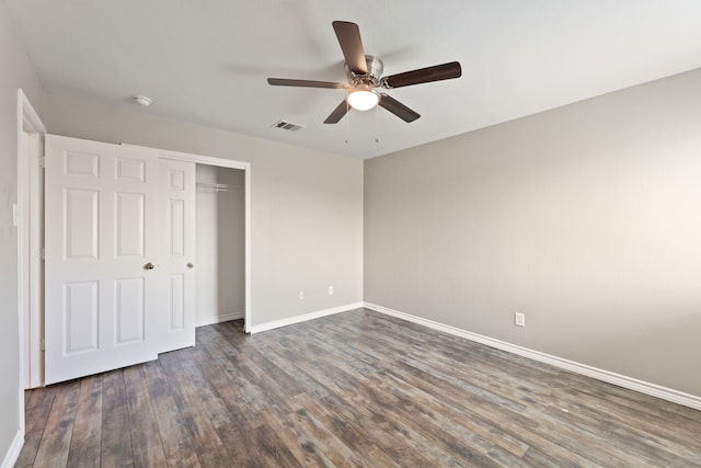 unfurnished bedroom with ceiling fan, dark hardwood / wood-style flooring, and a closet