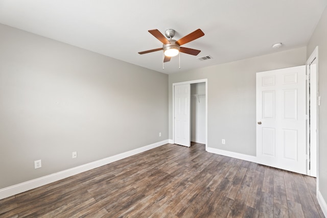 unfurnished bedroom with ceiling fan, a closet, and dark hardwood / wood-style floors