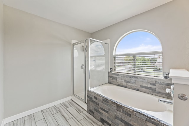 bathroom featuring shower with separate bathtub