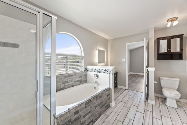 full bathroom featuring toilet, independent shower and bath, and vanity