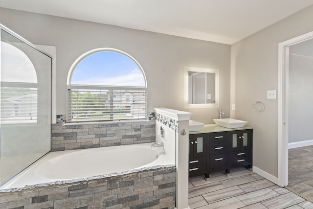 bathroom featuring tiled bath and vanity