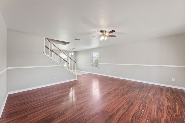 unfurnished room with ceiling fan with notable chandelier and dark hardwood / wood-style floors