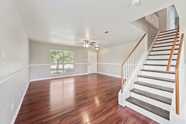 unfurnished living room featuring ceiling fan and dark wood-type flooring