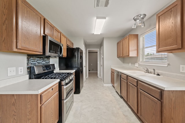 kitchen with decorative backsplash, sink, and stainless steel appliances