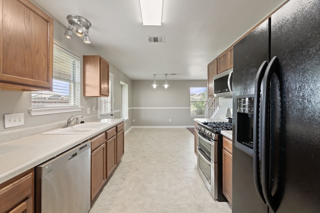 kitchen with stainless steel appliances, pendant lighting, and sink