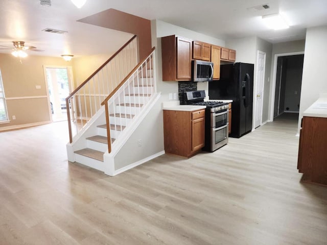 2700 Breezy Point Cv, Round Rock, TX 78665 - kitchen featuring stainless steel appliances, light wood-style flooring, ceiling fan, and brown cabinetry