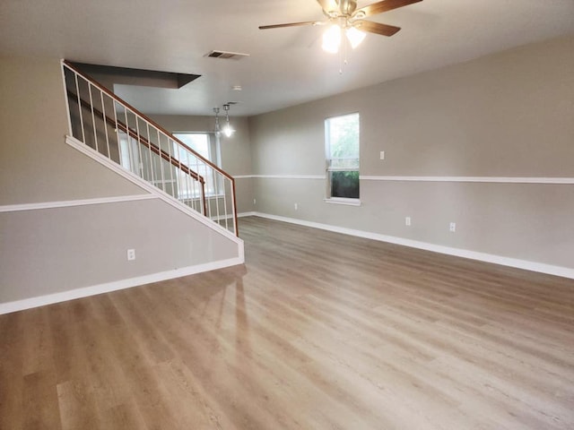 2700 Breezy Point Cv, Round Rock, TX 78665 - unfurnished living room with stairway, ceiling fan, wood finished floors, and baseboards