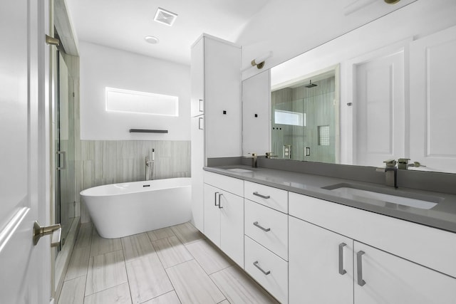 bathroom featuring vanity, tile walls, and independent shower and bath