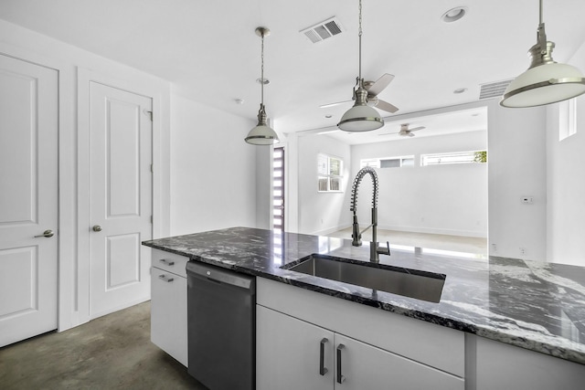 kitchen with dishwashing machine, sink, dark stone countertops, and pendant lighting