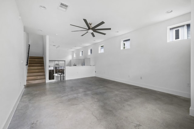 unfurnished living room with ceiling fan and concrete floors