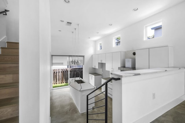 kitchen with a kitchen bar, white cabinets, kitchen peninsula, and a healthy amount of sunlight