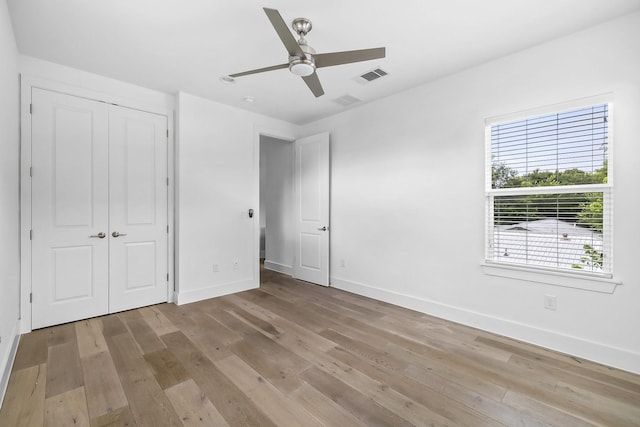 unfurnished bedroom with ceiling fan, a closet, and light hardwood / wood-style flooring