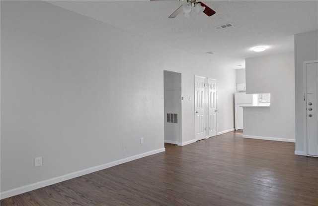 spare room featuring dark hardwood / wood-style floors, a textured ceiling, and ceiling fan