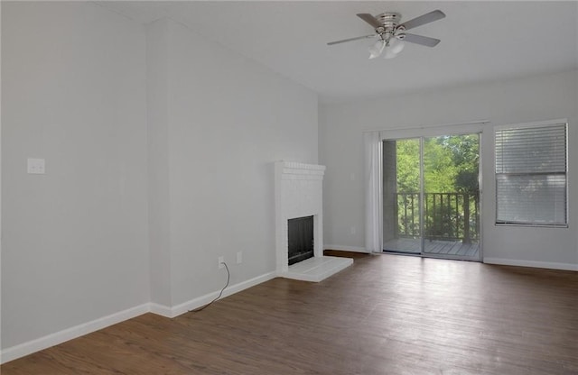 unfurnished living room with dark hardwood / wood-style flooring and ceiling fan