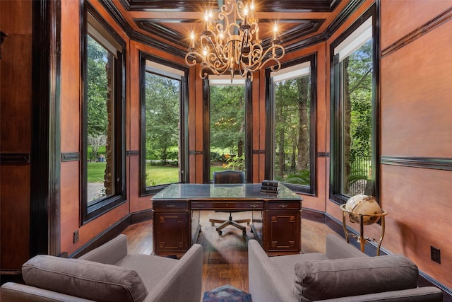 office space featuring a chandelier, ornamental molding, coffered ceiling, light hardwood / wood-style floors, and a healthy amount of sunlight