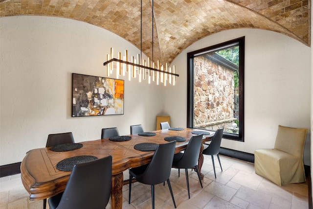 dining space featuring brick ceiling and vaulted ceiling