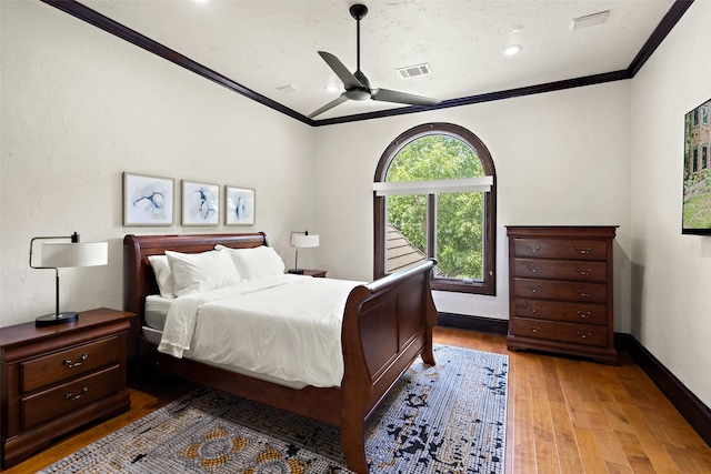 bedroom featuring wood-type flooring, ornamental molding, ceiling fan, and vaulted ceiling