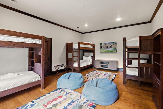 bedroom featuring crown molding and wood-type flooring