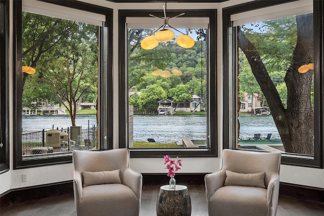 sitting room featuring a water view and a wealth of natural light