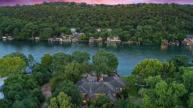 aerial view at dusk featuring a water view