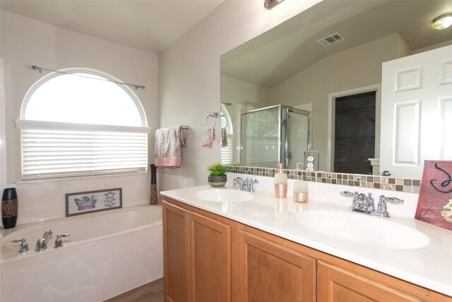 bathroom featuring dual vanity and plus walk in shower