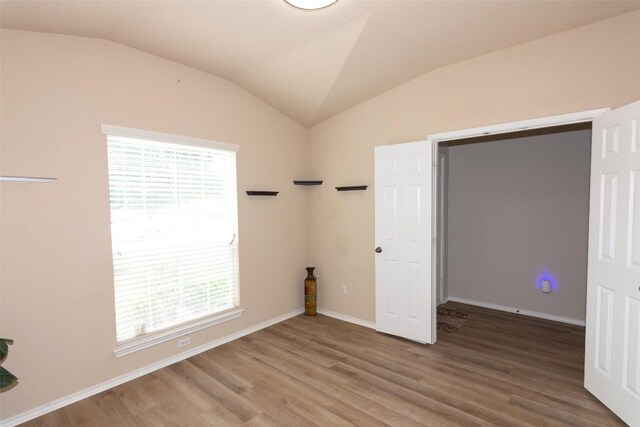 unfurnished bedroom featuring hardwood / wood-style floors and vaulted ceiling