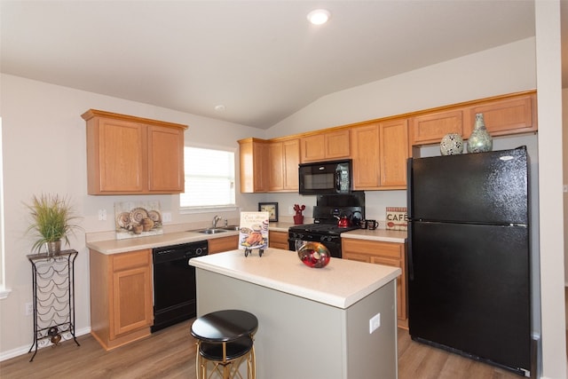 kitchen with a kitchen island, sink, black appliances, and light hardwood / wood-style floors