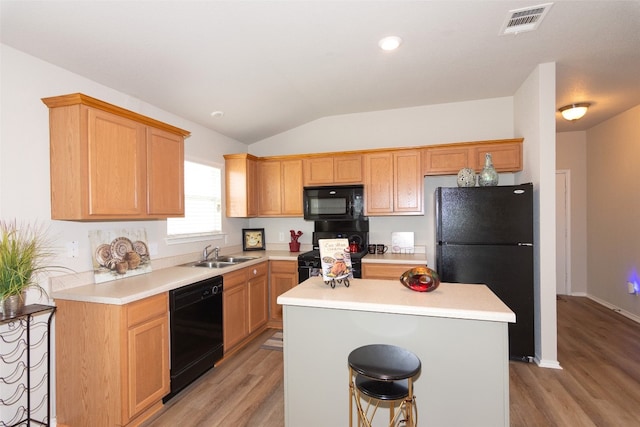 kitchen featuring a kitchen island, light wood-type flooring, and black appliances